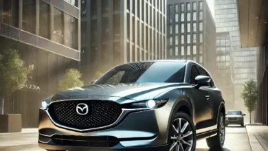 2025 Mazda CX-5 parked in an urban setting, showcasing its sleek design, elegant front grille, and glossy exterior.